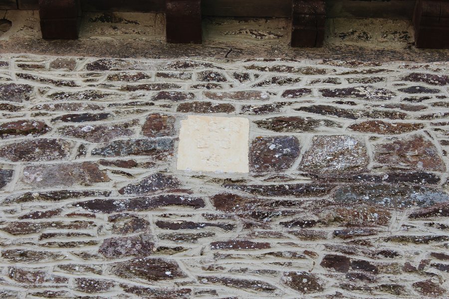 Blason abîmé sur un mur de l’église Saint-Pierre du Verger