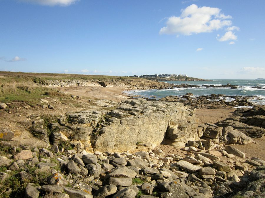 Küstenabschnitt zwischen Fort-Bloqué und Le Courégant mit niedrigen Klippen, Dünen und Le Courégant im Hintergrund