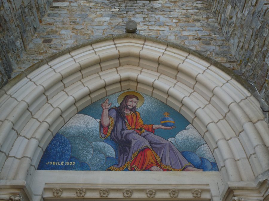 Façade principale de l’église Notre-Dame-de-la-Visitation à Gosné, avec son tympan et une mosaïque de l’atelier Odorico.