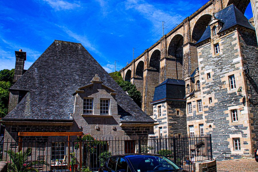 Historic half-timbered houses beneath the arches of the Morlaix Viaduct in Morlaix, Finistère, Brittany, France